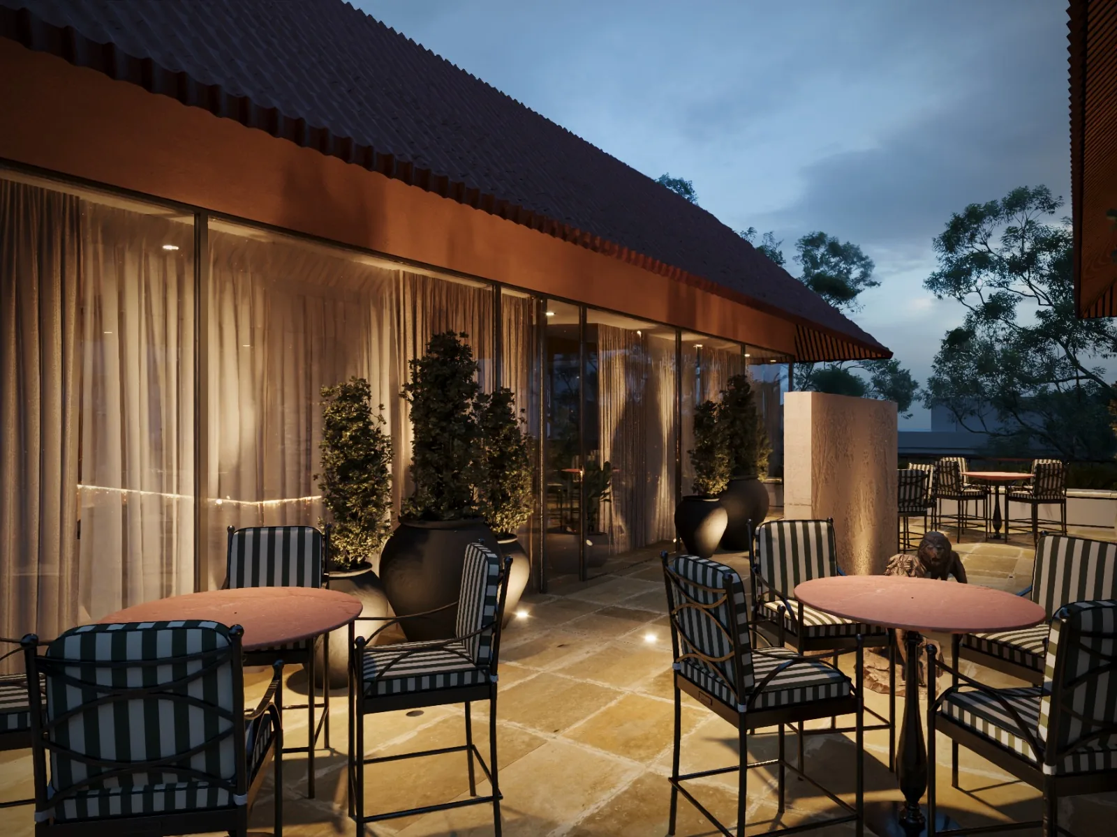The restaurant terrace at Sawai Traditional, Luxury Resort at dusk — round tables and striped chairs beside the glazed wall The restaurant terrace at Sawai Traditional, Luxury Resort at dusk — round tables and striped chairs beside the glazed wall